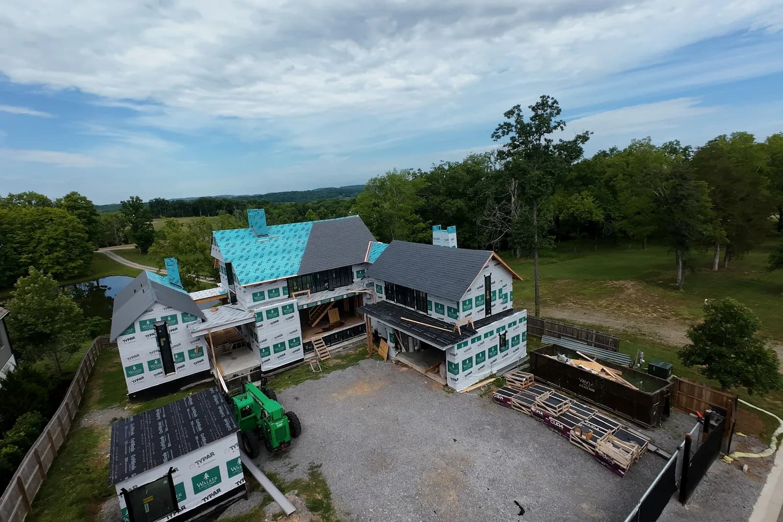 An AEM shingle replacement under way on a large Middle Tennessee house, half the roof still in underlayment and the finished courses running to the ridge.