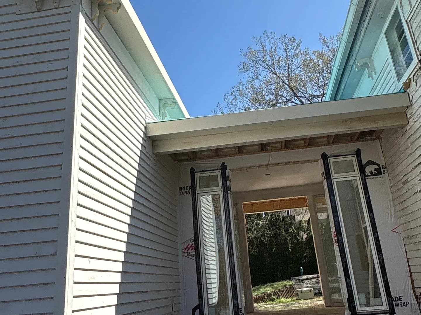 A gutter and fascia line running across a porch on a Middle Tennessee house, copper against white siding.