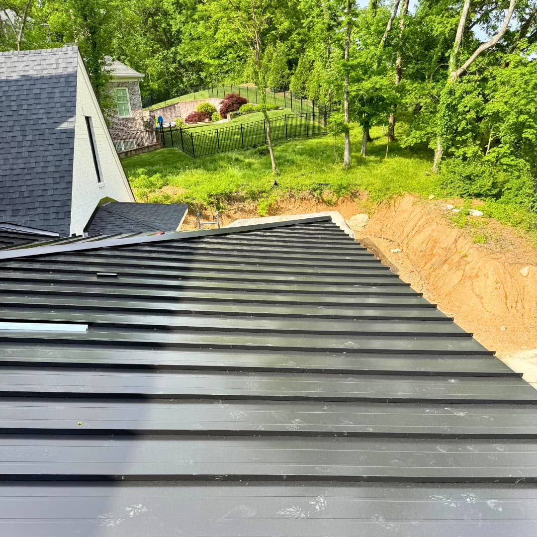 Standing-seam panels running down a roof mid-installation, the crew's chalk marks still on them.